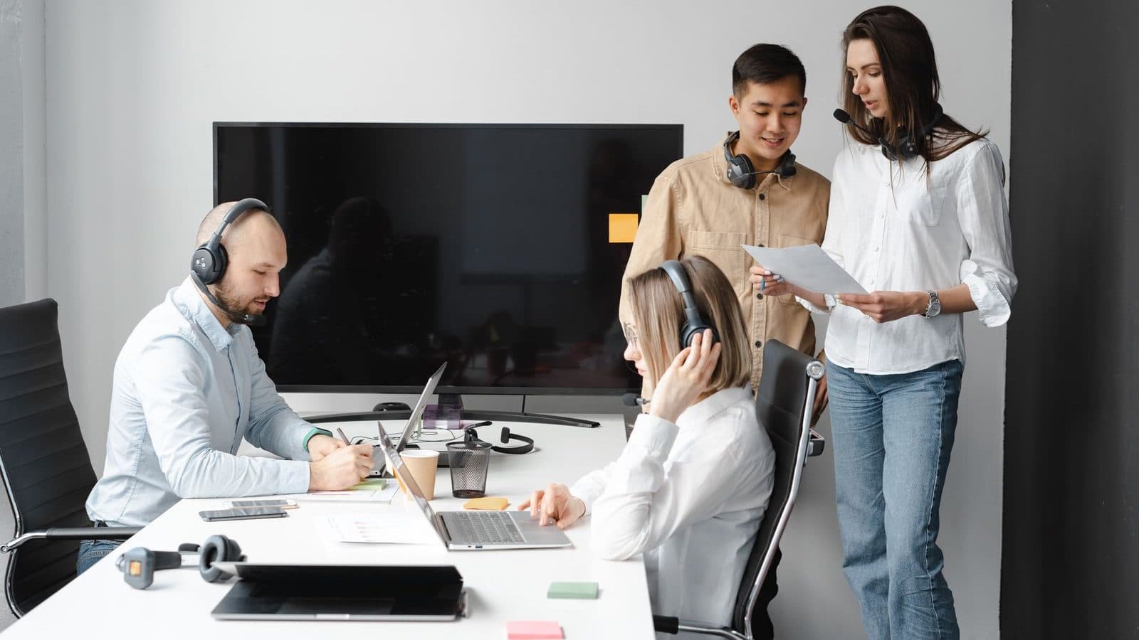 Equipe de atendimento reunida em torno de notebooks