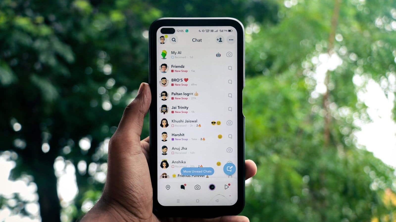 Mão segurando celular com lista de conversas aberta